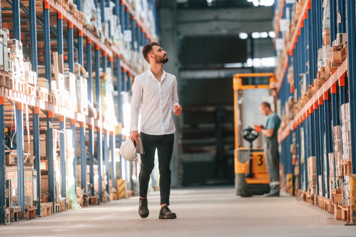 Worker using tablet to check warehouse storage inventory